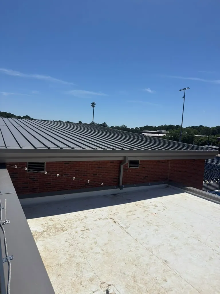 White TPO roof next to a standing seam metal roof on a commercial building