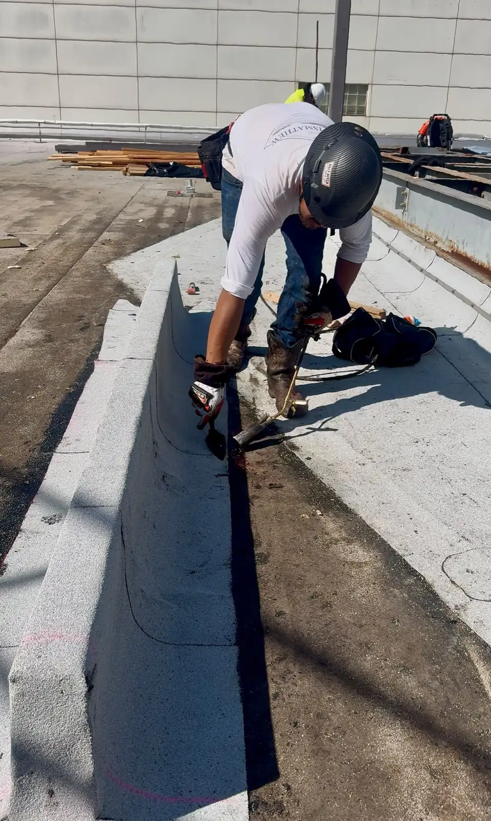 Roofer heat-welding TPO membrane seams on a commercial roof