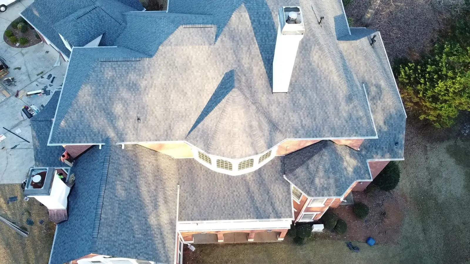 Overhead drone view of a complex gray shingle roof with multiple valleys